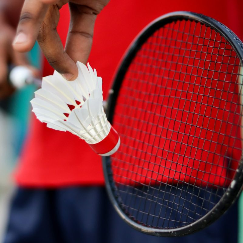 person holding red and black tennis racket